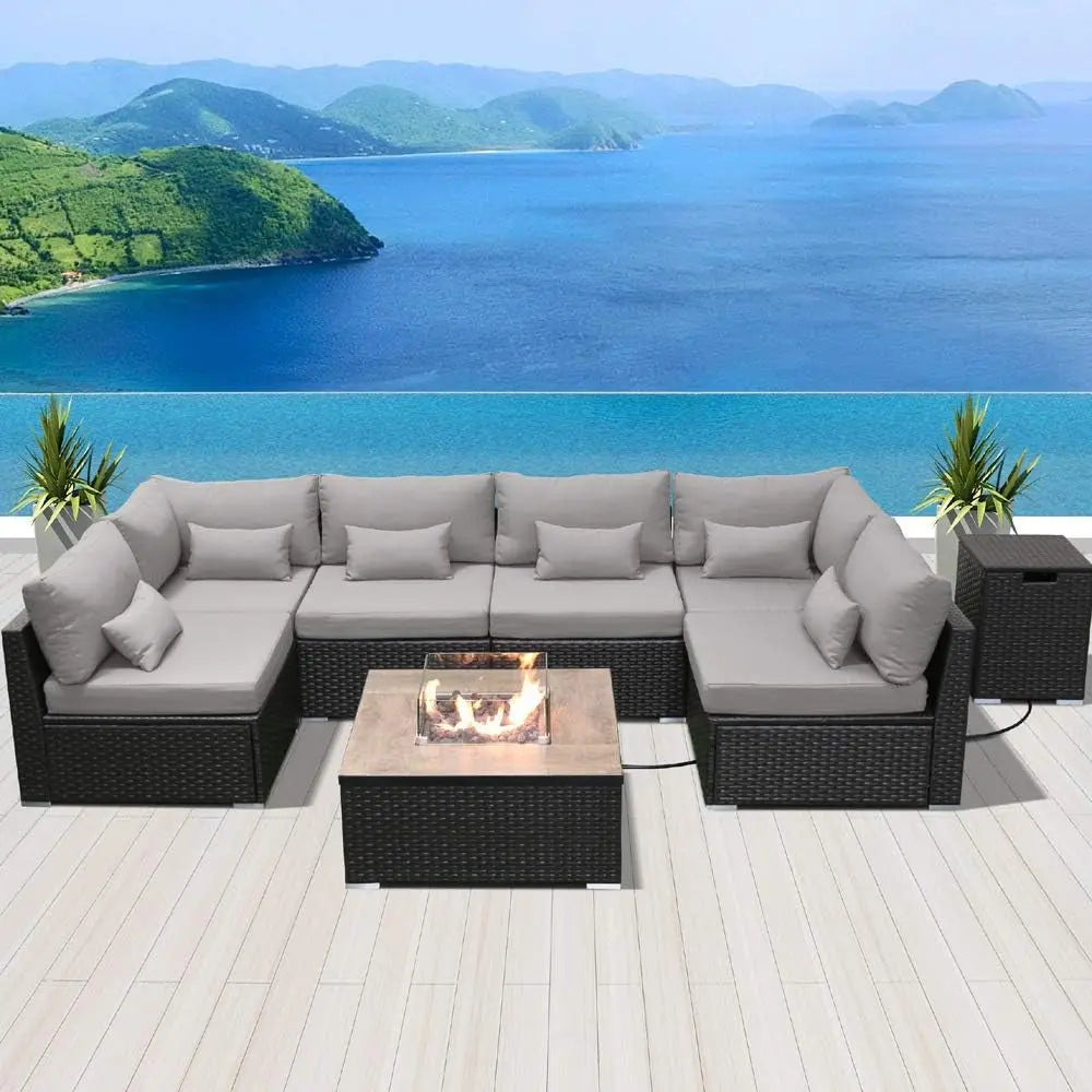 Outdoor rattan patio sectional sofa with grey cushions and fire pit overlooking ocean view