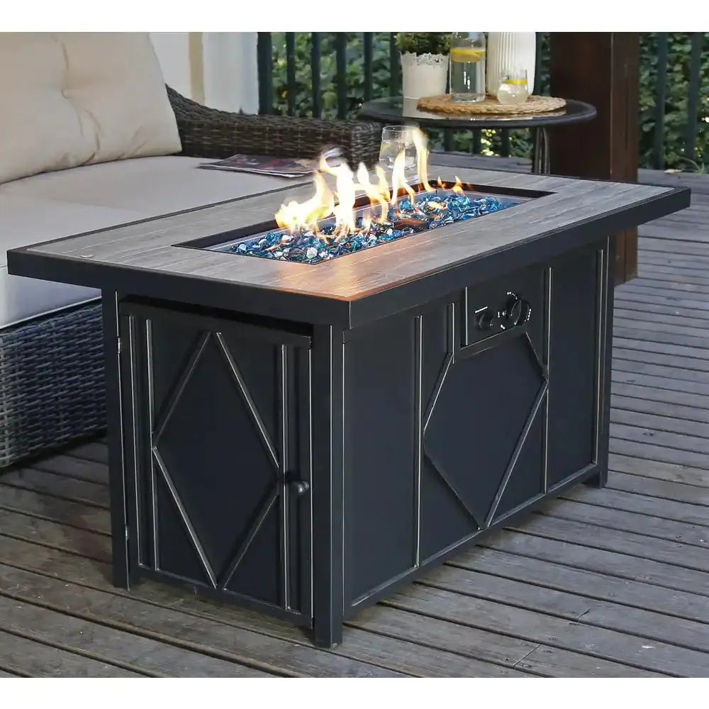 Modern outdoor patio fire pit table with glass stones on wooden deck